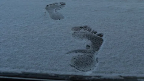 Two Fresh Bare Human Footprints in Shallow Snow