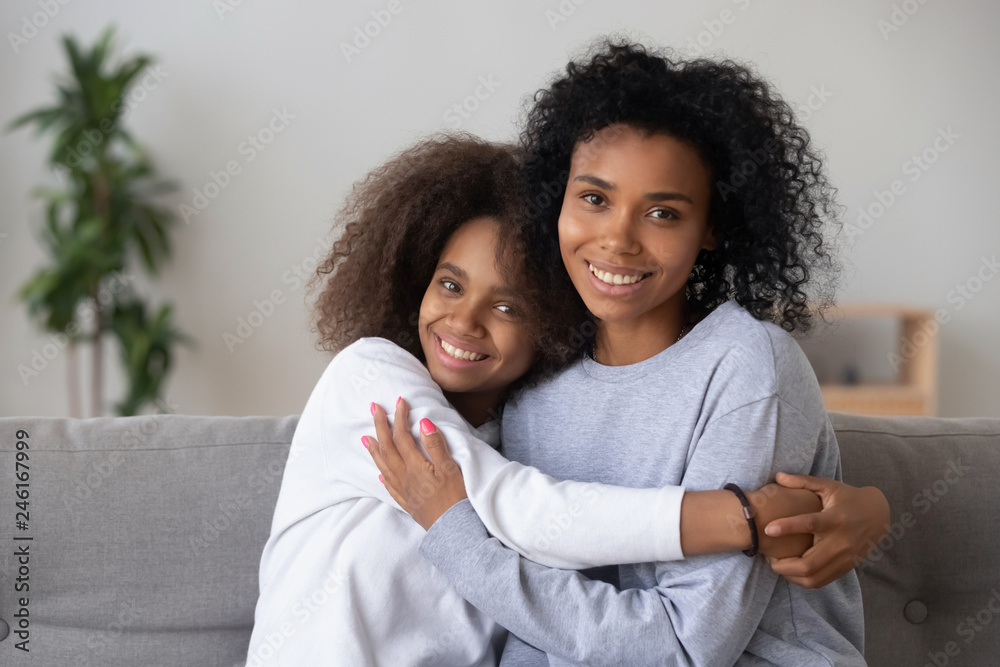 Portrait of happy African American mom and teen daughter spend ...