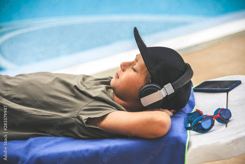 Young boy relaxing outdoor, listening online music with smartphone ...