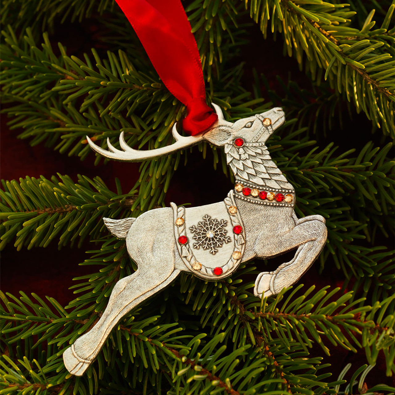 A christmas reindeer with a red nose and a wreath on its head ...