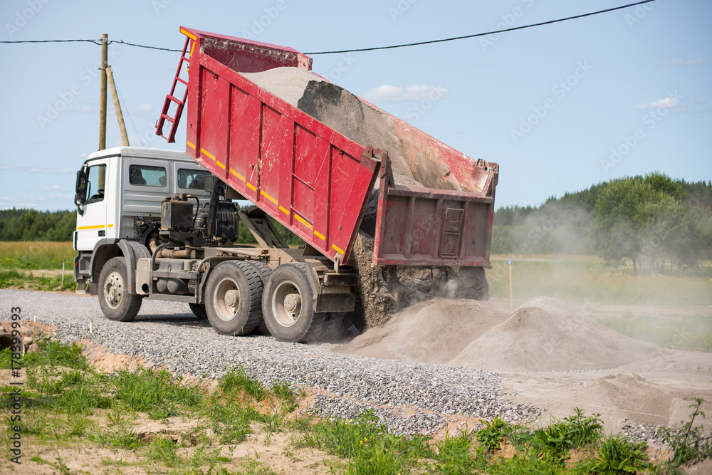 Dump truck is unloading soil. Dumper truck is unloading soil or ...