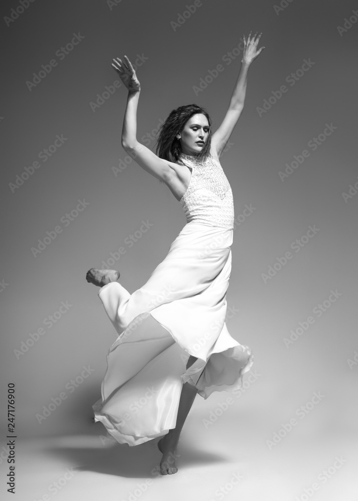 woman dancing classic dance in white dress on gray background ...
