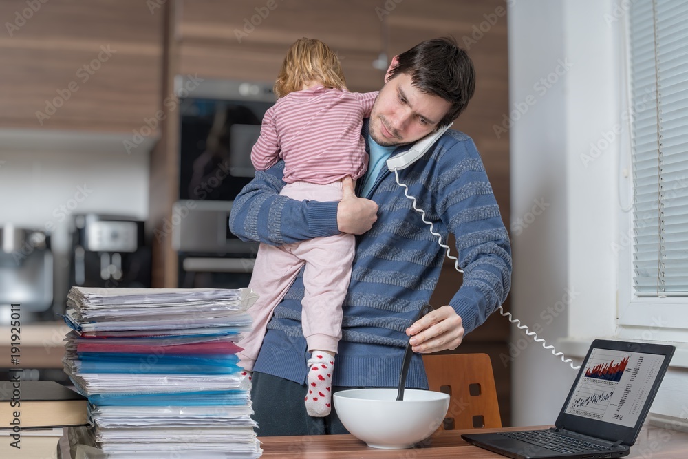 Multitasking father is babysitting and working at home. Stock-Foto ...