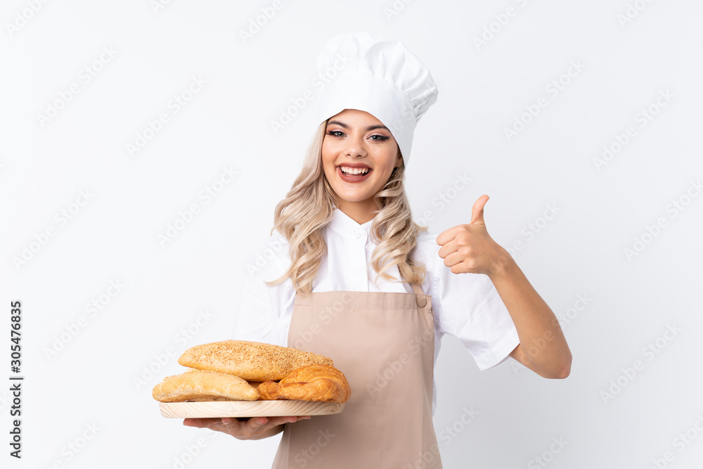 Teenager girl in chef uniform. Female baker holding a table with ...