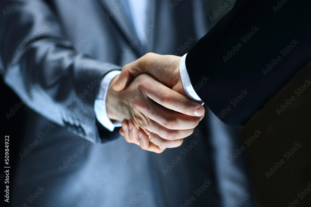 Handshake - Hand holding on black background Stock-Foto | Adobe Stock
