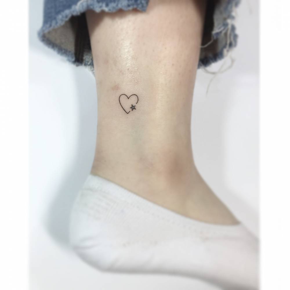 Minimalistic heart and star tattoo located on the