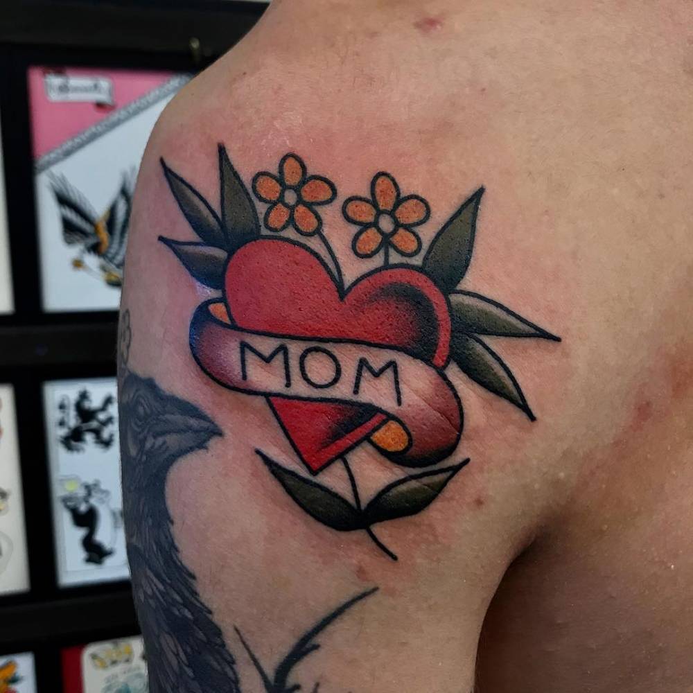 Mom heart and banner tattoo on the shoulder.