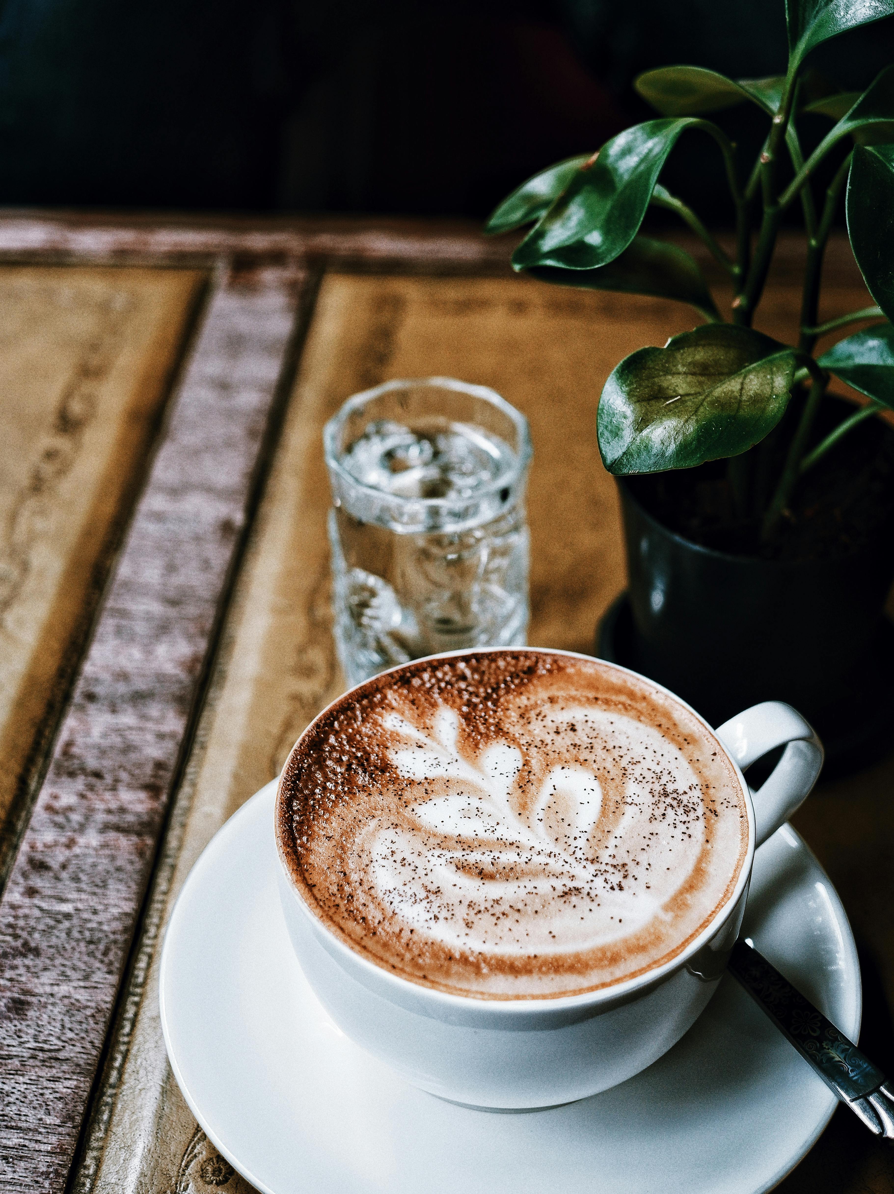 Delicious hot coffee in a white cup with smoke on a dark wooden ...