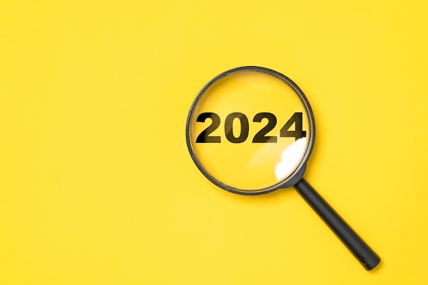 Premium Photo | 2024 year inside of magnifier glass on yellow ...