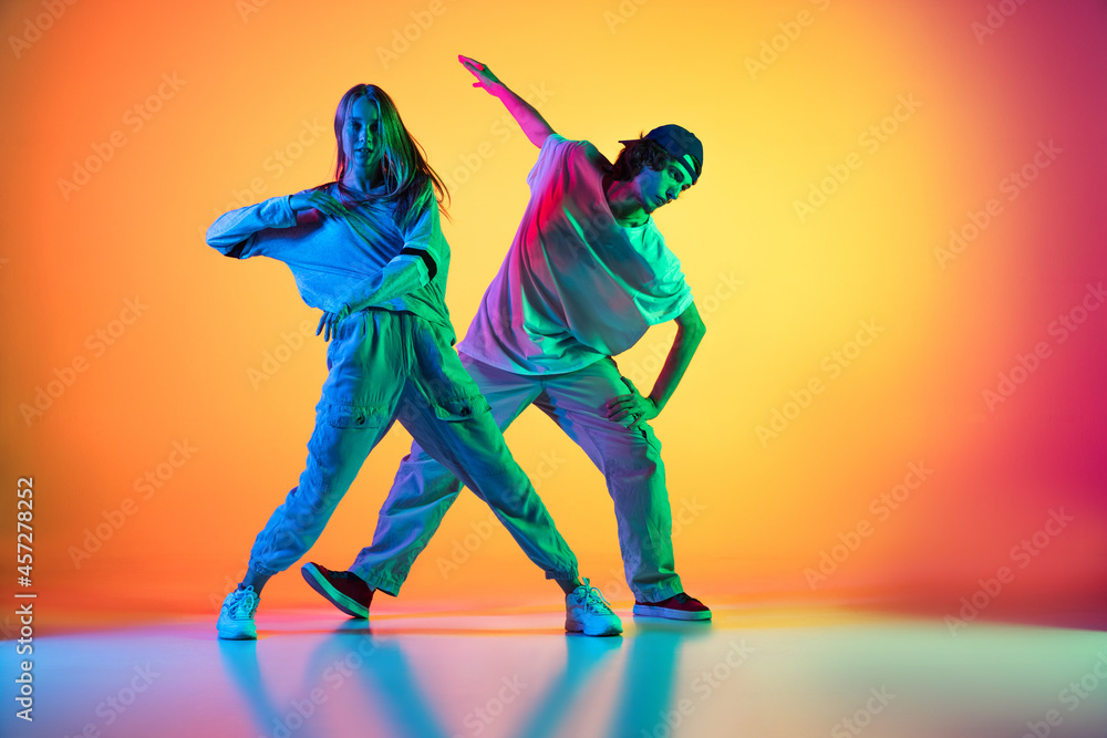 Two dancers, young girl and boy dancing hip-hop in casual sports ...