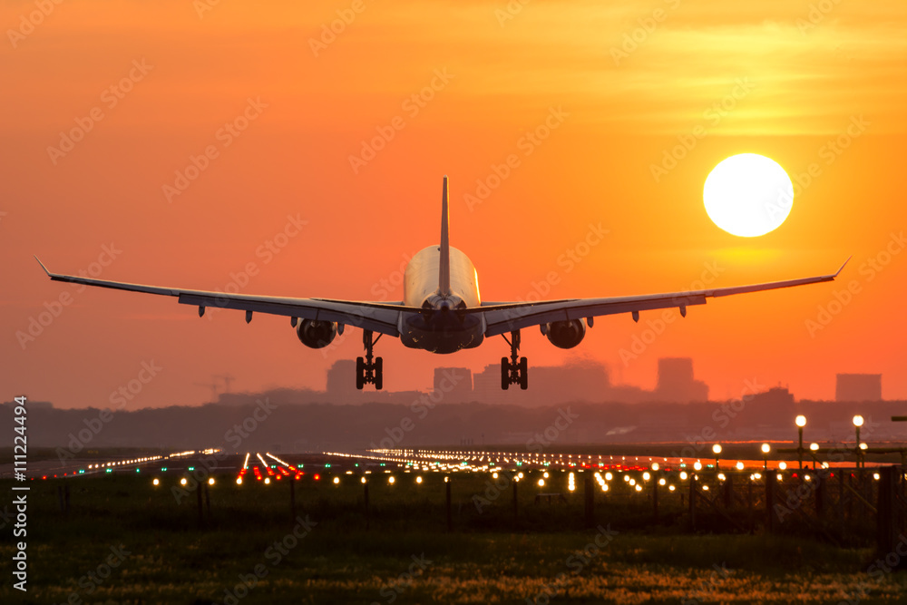 Poster, Wandbilder Passenger plane is landing during a wonderful sunrise.,  40x26.7 cm