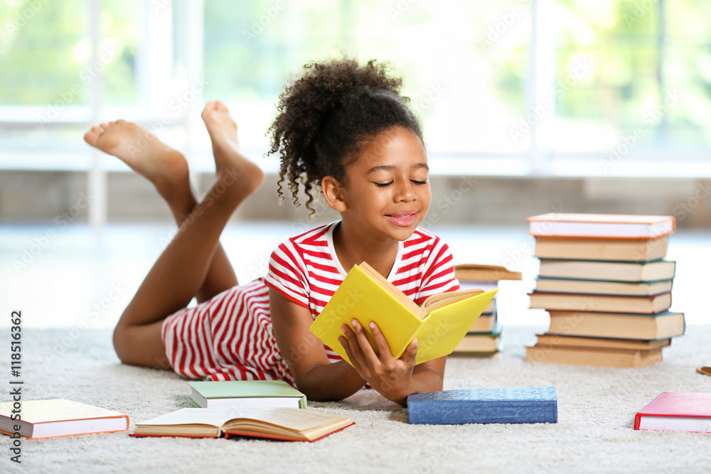 Cute girl reading book at home Stock-Foto | Adobe Stock