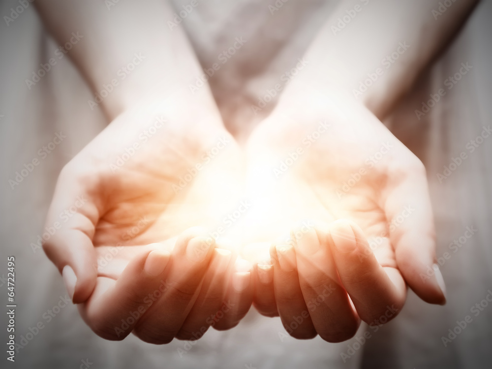 Leinwanddruck The light in young woman hands. Sharing, giving ...