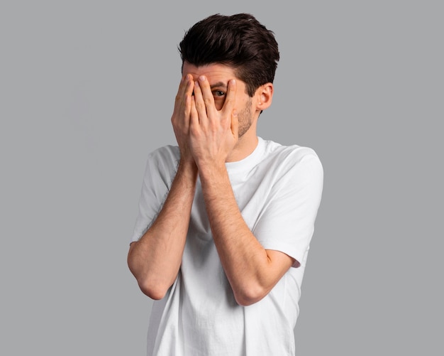 Free Photo | Front view of shy man covering his eyes with his hands