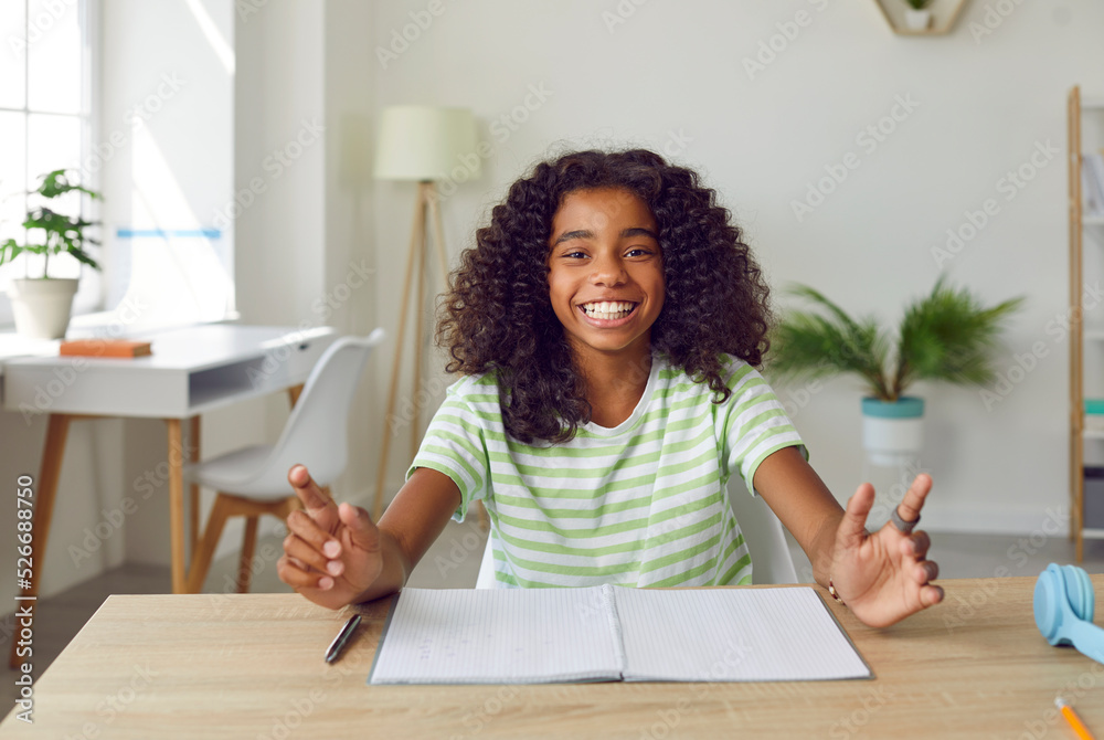 Happy school child sitting at desk at home. Portrait of cheerful ...