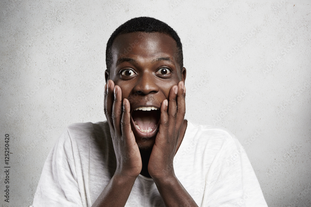 Stock-Foto „African employee or customer with shocked and ...