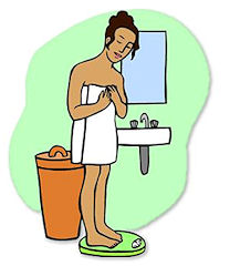 Woman in towel standing on scale beside trash bin and sink, checking weight after shower.