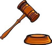 Wooden judge's gavel poised above a sound block, symbolizing legal authority and courtroom proceedings.