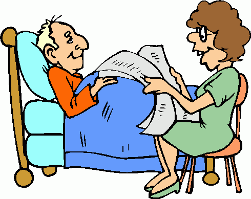 A nurse reviews medical documents with an elderly male patient lying in a hospital bed.