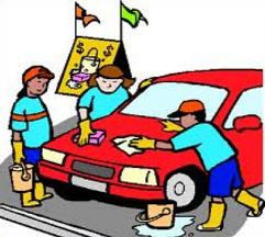 Three children washing a red car with sponges and buckets, smiling under colorful flags.