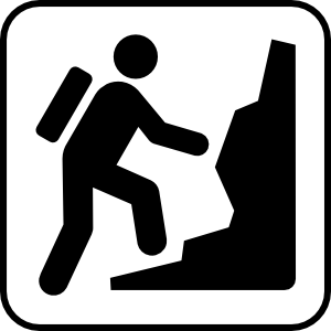 Silhouette of a hiker with backpack ascending a steep rocky trail, indicating hiking or mountain climbing activity.