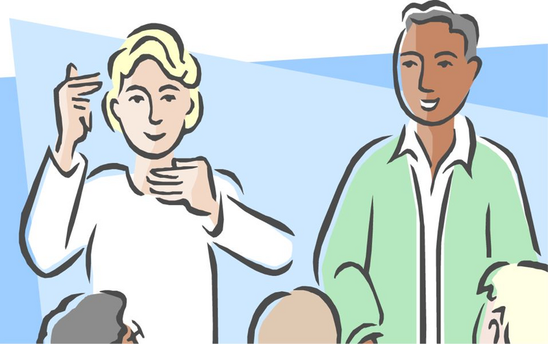 Two diverse individuals communicating with sign language in a group setting.