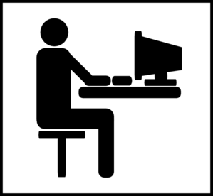 Silhouette of a person sitting at a desk using a computer monitor.