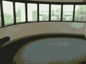 Curved interior wall with large panoramic windows overlooking greenery and a circular carpeted floor area.