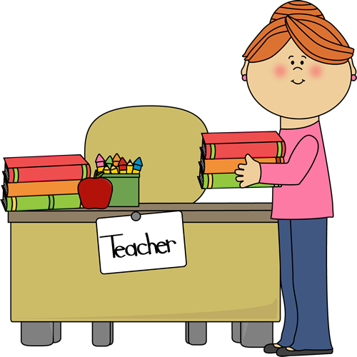 A smiling teacher with red hair stands beside a desk holding books, with a "Teacher" sign, apples, and crayons on the desk.