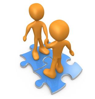 Two orange 3D figures shaking hands on interlocking blue puzzle pieces, symbolizing teamwork and collaboration.