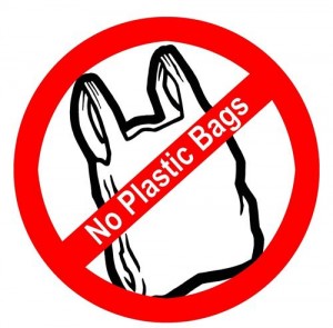 Red prohibition symbol over a plastic bag with "No Plastic Bags" text, indicating a ban on single-use plastic bags.