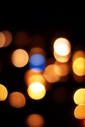 Bokeh effect of warm and cool out-of-focus city lights at night, creating a dreamy abstract background.