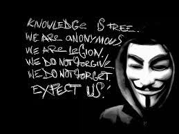 Anonymous activist wearing Guy Fawkes mask with handwritten manifesto text on black background.