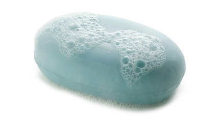 A light blue bar of soap with rich white lather on a clean white background.