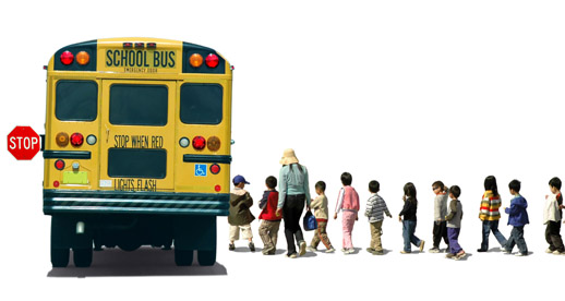 A yellow school bus with its stop sign extended as a diverse group of children and an adult walk toward it.
