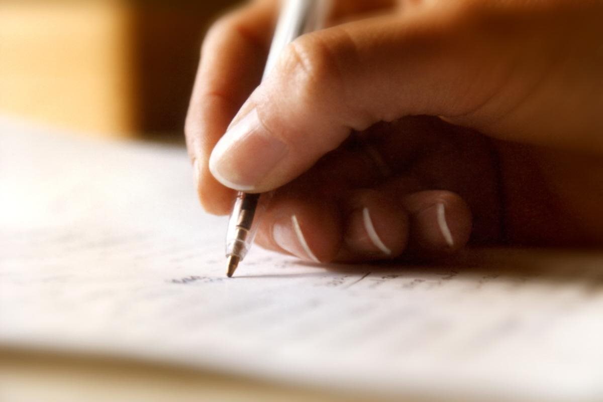 Hand Writing with Pen on Paper - Focused Note-Taking in Action