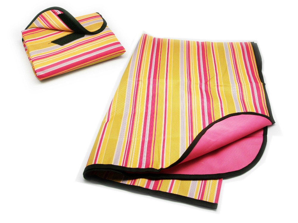 Brightly striped portable picnic blanket in yellow, pink, and white, shown both folded with carry strap and partially unfolded.