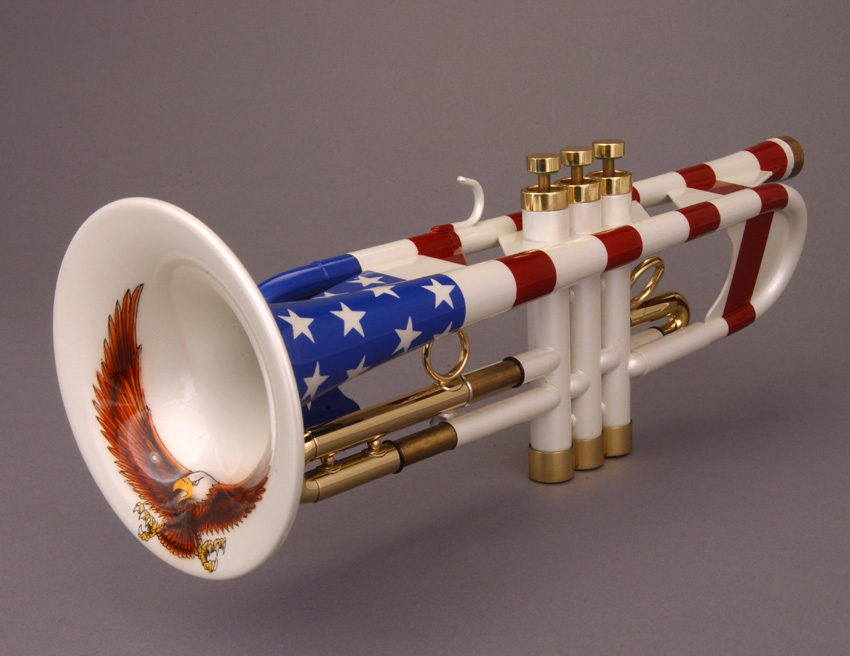 Patriotic trumpet with American flag motif and bald eagle painting on bell, gold valves, white body with red stripes.