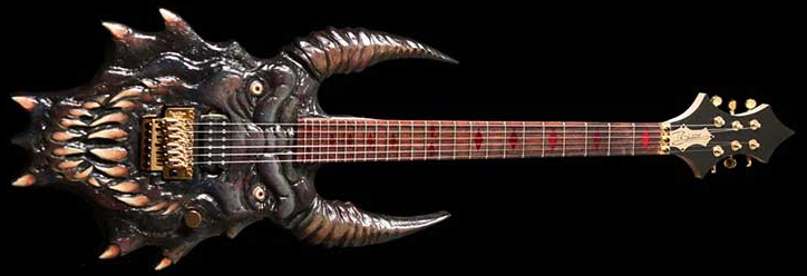 A custom electric guitar sculpted as a menacing dragon head with horns, fangs, and textured scales, set against black.