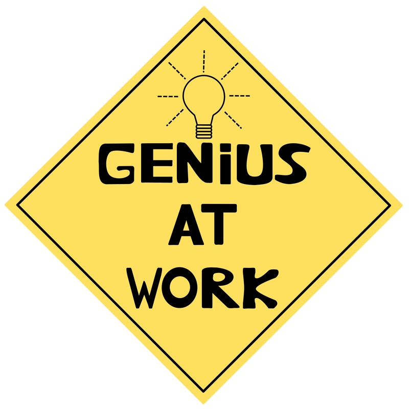 Yellow diamond-shaped sign with "GENIUS AT WORK" text and a lightbulb icon above, styled like a caution sign.