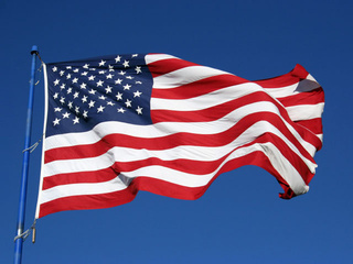 U.S. Flag Waving in Blue Sky - Patriotic Symbol of Freedom