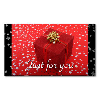 Red gift box with gold bow on festive red background with white stars and "Just for you" text.