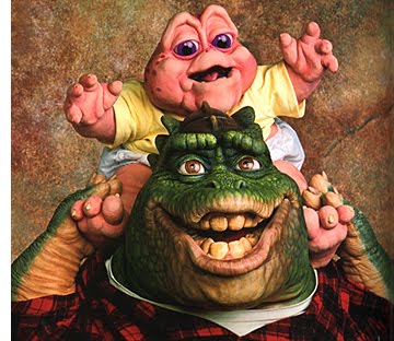 A cheerful green dinosaur with a wide grin carries a pink baby dinosaur on its shoulders, both smiling joyfully against a textured backdrop.