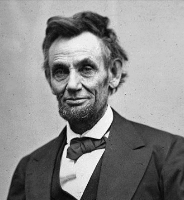 Portrait of Abraham Lincoln, 16th U.S. President, in formal attire with beard and bow tie, black-and-white photograph.