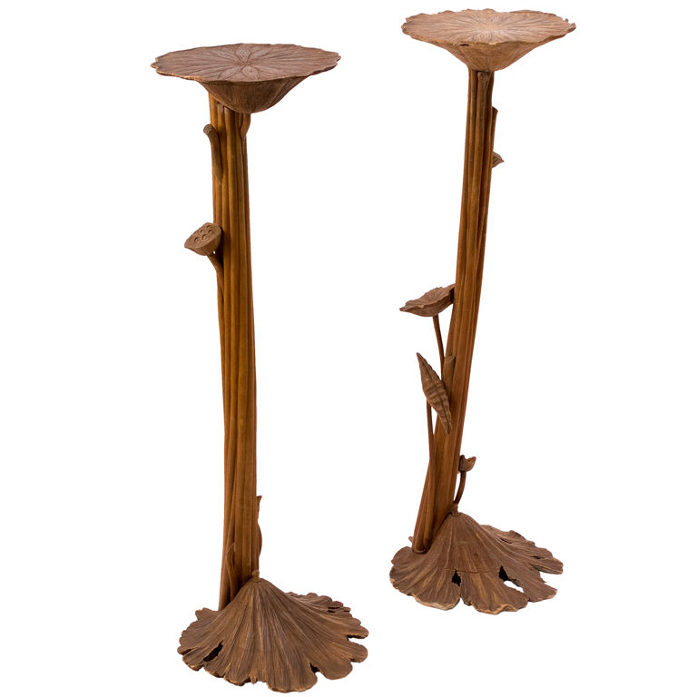 Two hand-carved wooden plant stands shaped like lotus flowers with stems and leaves, finished in natural wood tone.