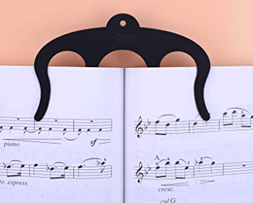 Black music book holder clip holding open a sheet music book with musical notation.